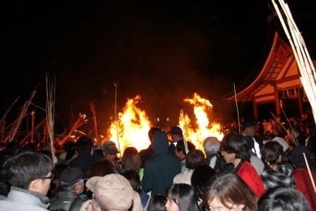 大松明の燃え残りを競って拾う参拝者の様子