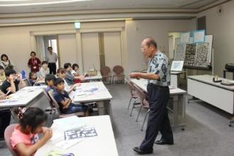 画像　講師の上田氏が音楽に合わせて切り紙を作っている様子