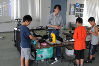 画像　缶バッチを作る子どもたち