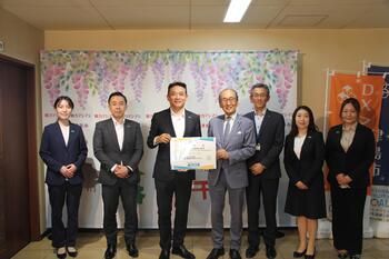 細井支社長と日比市長が目録を交わす写真