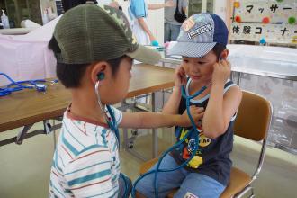 画像　聴診器の体験をする子ども