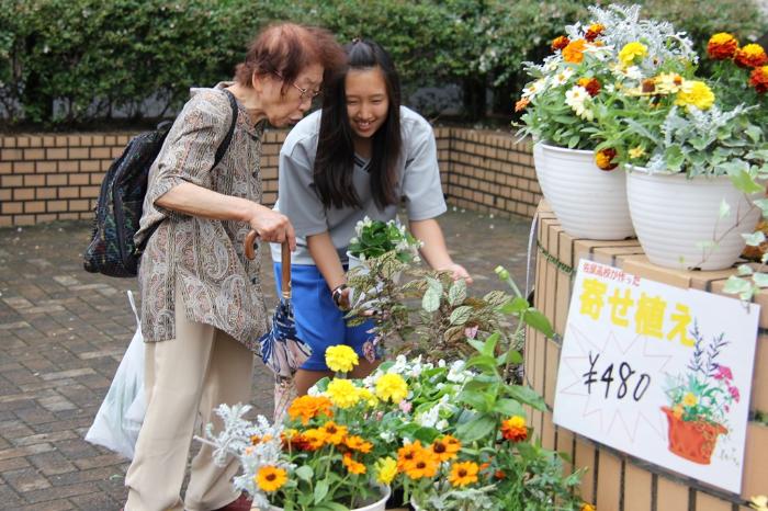 画像　バザー会場にて商品の説明をする生徒