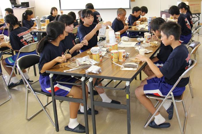 画像　災害用備蓄食品を試食する生徒