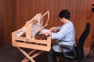 手織り機で織る様子の写真