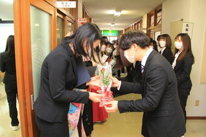 画像　在校生から卒業生へ花束を手渡す様子