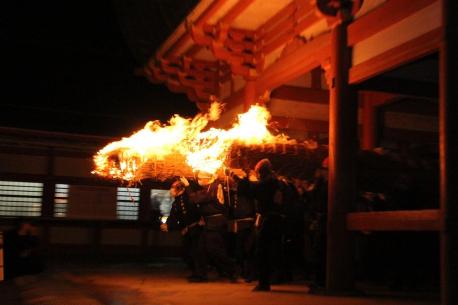 画像　楼門を潜り抜ける大松明（横から）